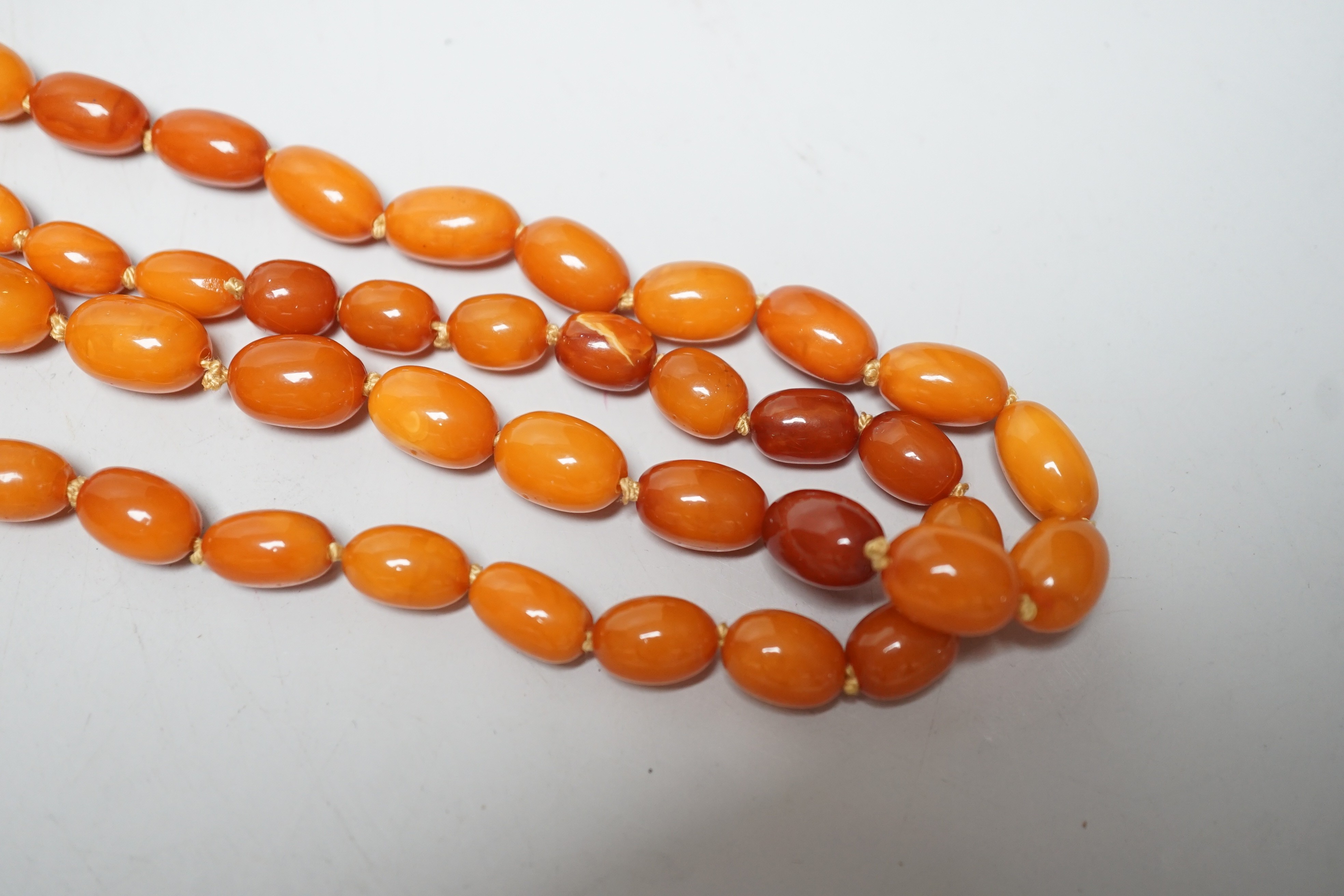 A long single strand graduated oval amber bead necklace(string broken), 142cm, gross weight 51 grams.